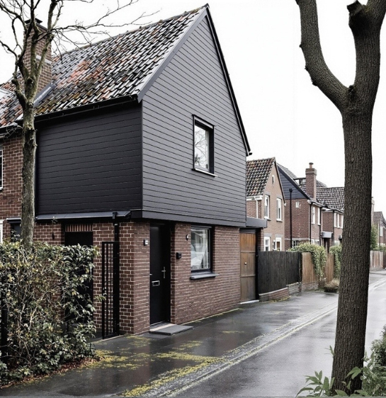 Woning met donkere kunststof gevelbekleding op de eerste verdieping